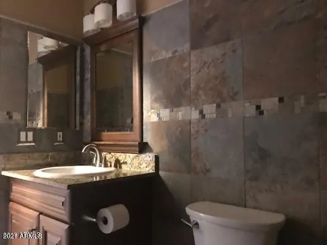 a bathroom with a sink vanity mirror and toilet