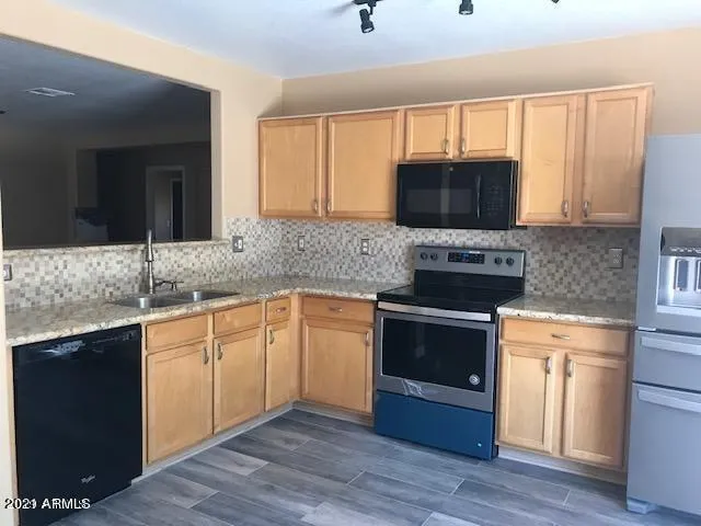 a kitchen with granite countertop a stove top oven sink and cabinets