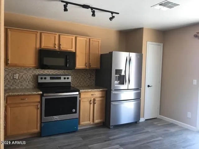 a kitchen with stainless steel appliances a refrigerator stove and microwave