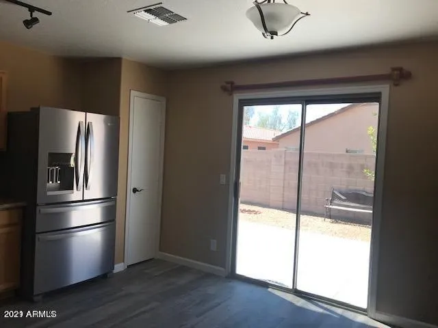 a kitchen with a refrigerator and wooden floor