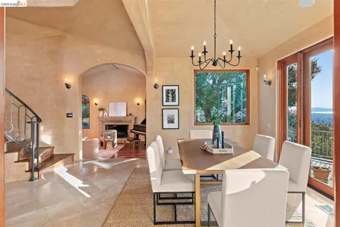 a dining room with wooden floor a chandelier a wooden table and chairs