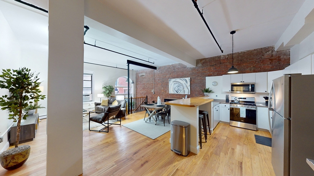 19 Stanhope Street, Unit 1D Boston, MA 02116 - Photo 2 of 30 a living room with stainless steel appliances kitchen island granite countertop furniture wooden floor and a kitchen view