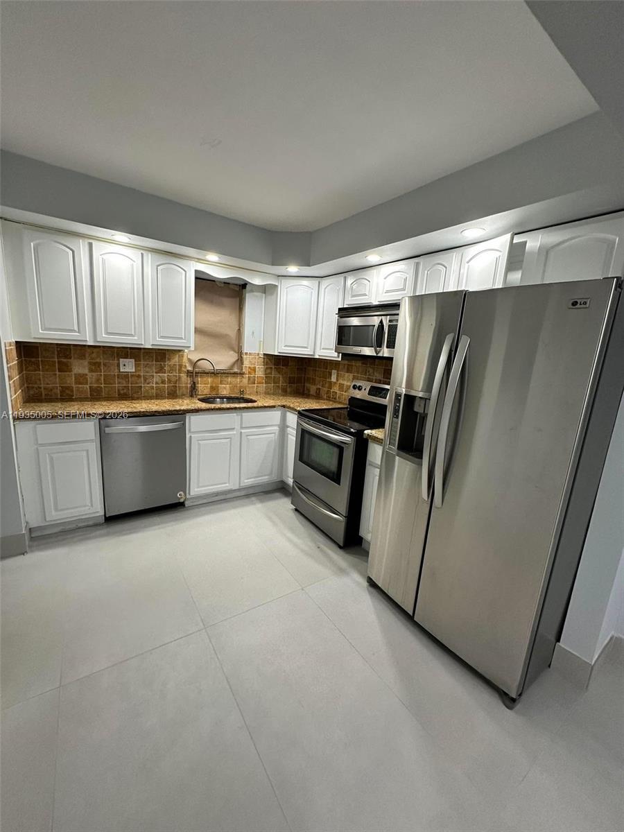 9440 Southwest 8th Street, Unit 402 Boca Raton, FL 33428 - Photo 8 of 45 a kitchen with granite countertop a refrigerator and a stove top oven