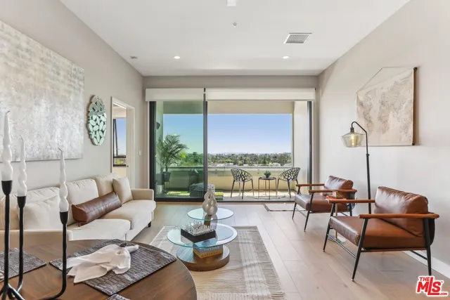 a living room with furniture table and a large window