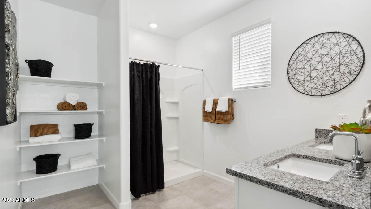 8459 West Gehrig Way Florence, AZ 85132 - Photo 11 of 37 a bathroom with a granite countertop sink and a mirror