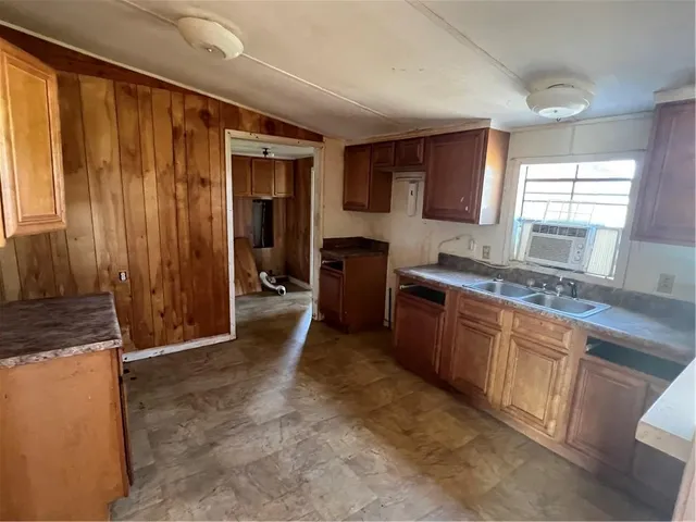 a large kitchen with granite countertop a sink and a stove top oven