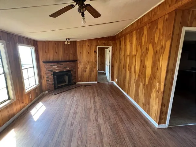 a view of empty room with wooden floor and fireplace