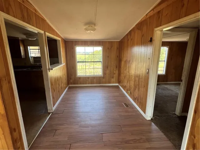 a view of a hallway with wooden floor and staircase