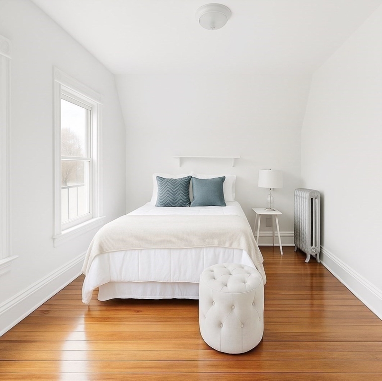 145 Lagrange Street, Unit 2 Boston, MA 02132 - Photo 13 of 17 a bedroom with a bed and wooden floor