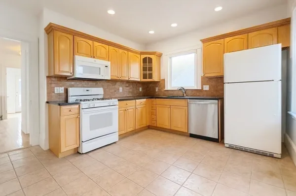 a kitchen with white cabinets and white appliances