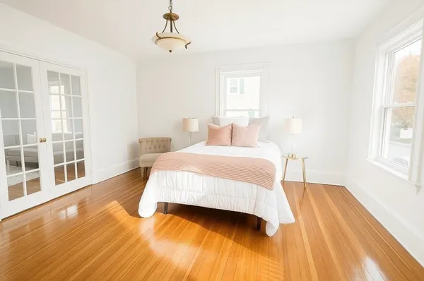 a bedroom with a bed and wooden floor