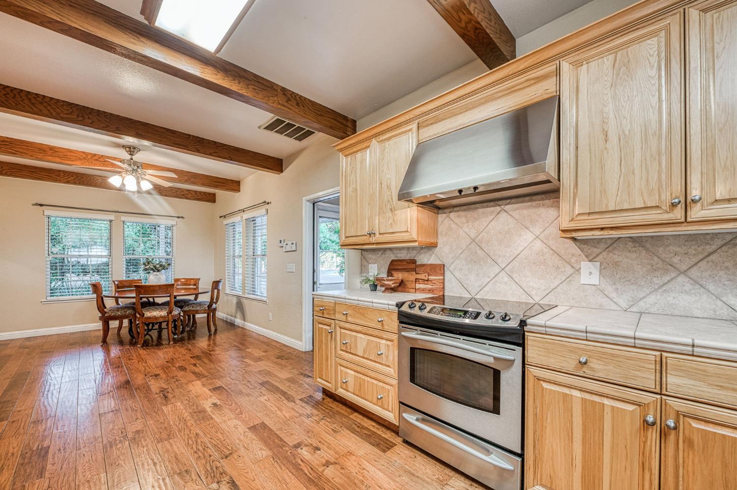 1098 South Rainbow Route Sanger, CA 93657 - Photo 42 of 70 a kitchen with granite countertop a stove top oven cabinets and wooden floor