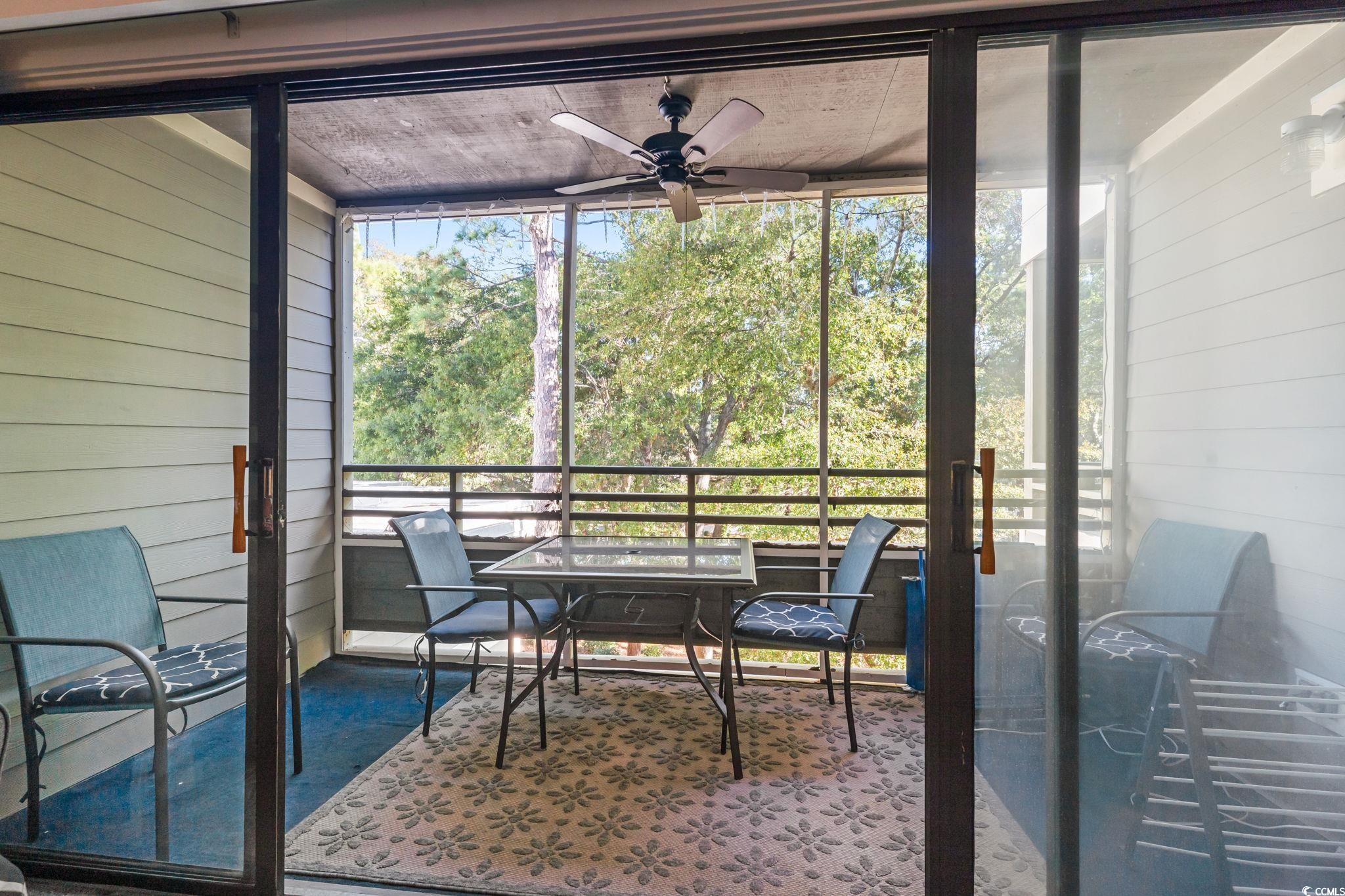 415 Ocean Creek Drive, Unit 2343 Myrtle Beach, SC 29572 - Photo 22 of 36 Sunroom with a ceiling fan and outdoor dining area