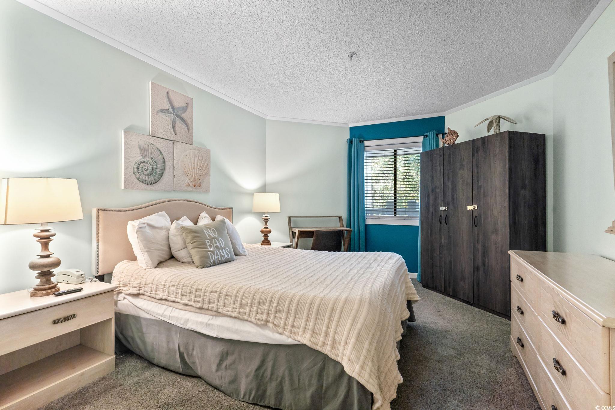 415 Ocean Creek Drive, Unit 2343 Myrtle Beach, SC 29572 - Photo 6 of 36 Bedroom featuring crown molding, carpet floors, and a textured ceiling