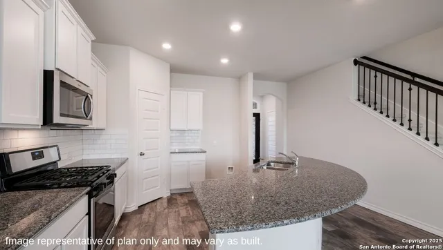 a kitchen with stainless steel appliances granite countertop a sink stove and cabinets