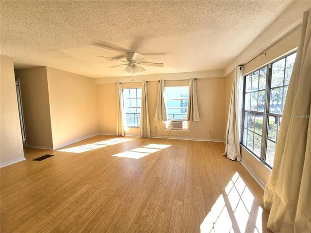 a view of an empty room with glass door and wooden floor