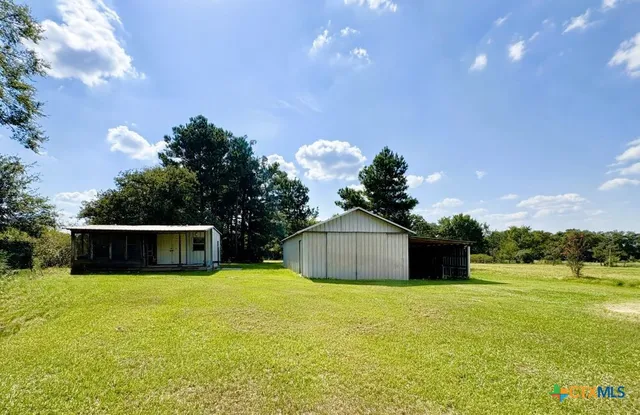 a big yard with lots of green space and trees all around