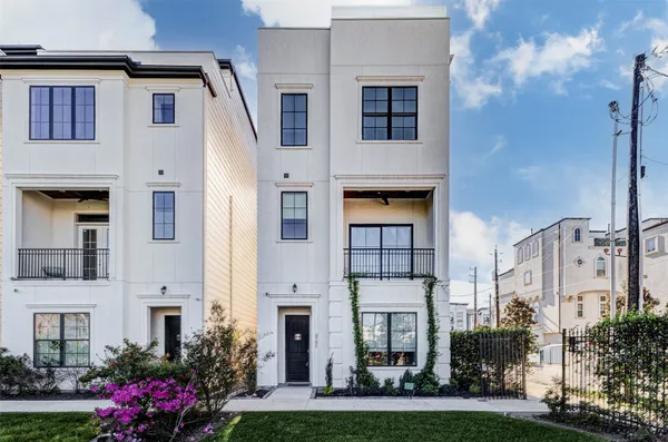 a front view of a multi story residential apartment building with yard and retail shops