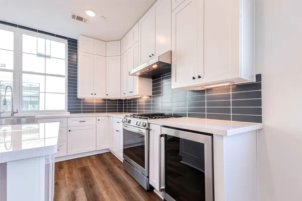 a kitchen with stainless steel appliances white cabinets and a stove