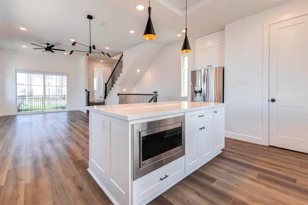 a kitchen with a sink and wooden floor