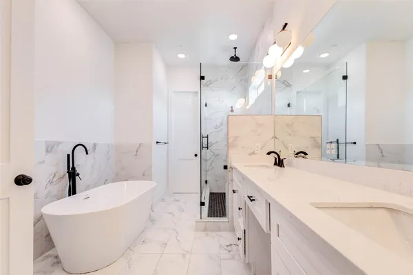 a spacious bathroom with a tub sink and mirror
