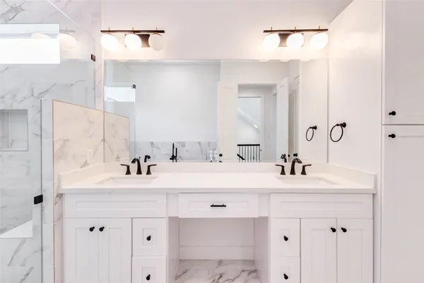 a bathroom with a sink vanity mirror and shower