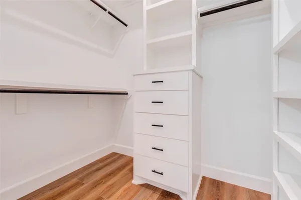 a view of walk in closet with empty racks
