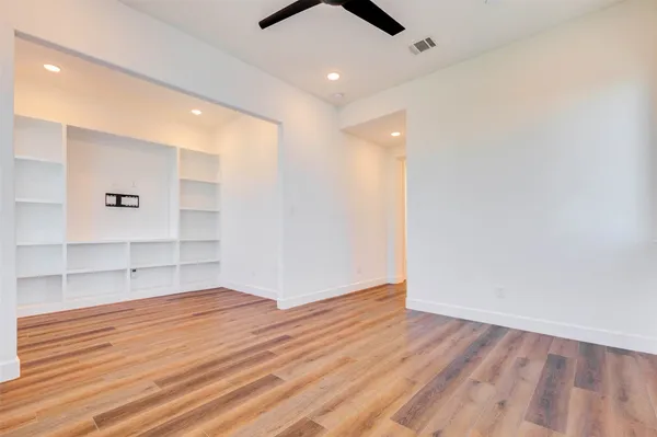 an empty room with wooden floor and windows