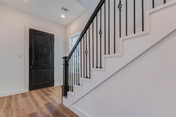 a view of a hallway with wooden floor and entryway