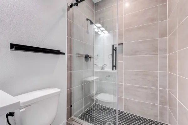 a bathroom with a toilet and a shower