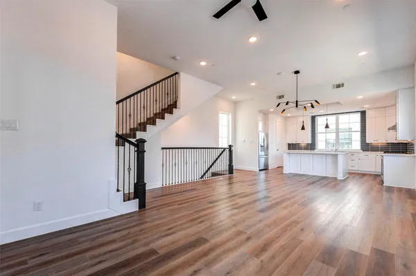 a view of a living room with wooden floor and windows