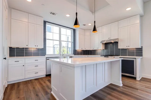 a kitchen with white cabinets and sink