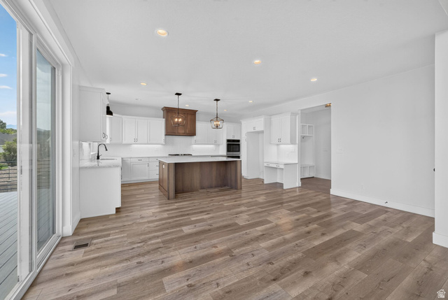 1002 West Temple Rim Lane Payson, UT 84651 - Photo 14 of 68 Open-concept kitchen featuring white cabinetry, a large wood-finish island with a stone countertop, and wood-finish flooring