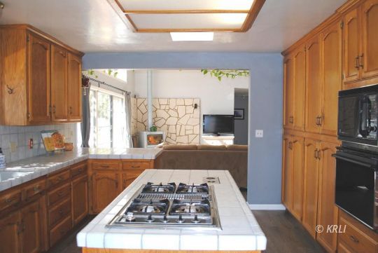 595 Evans Road Wofford Heights, CA 93285 - Photo 14 of 43 a kitchen with a stove a sink and a refrigerator