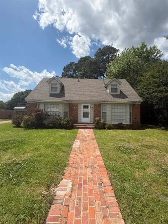 a front view of a house with a garden