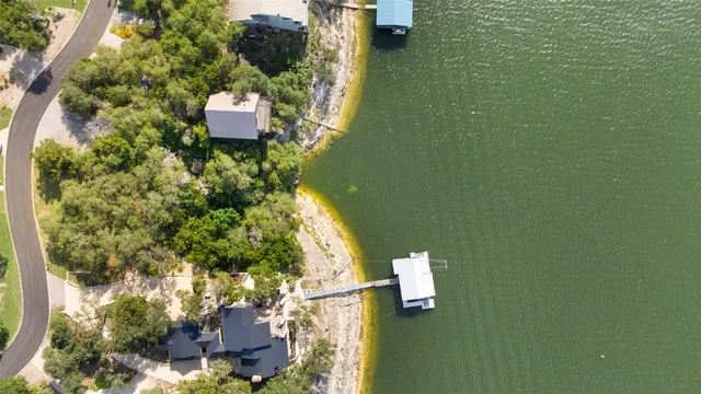 an aerial view of a house with a yard and lake view