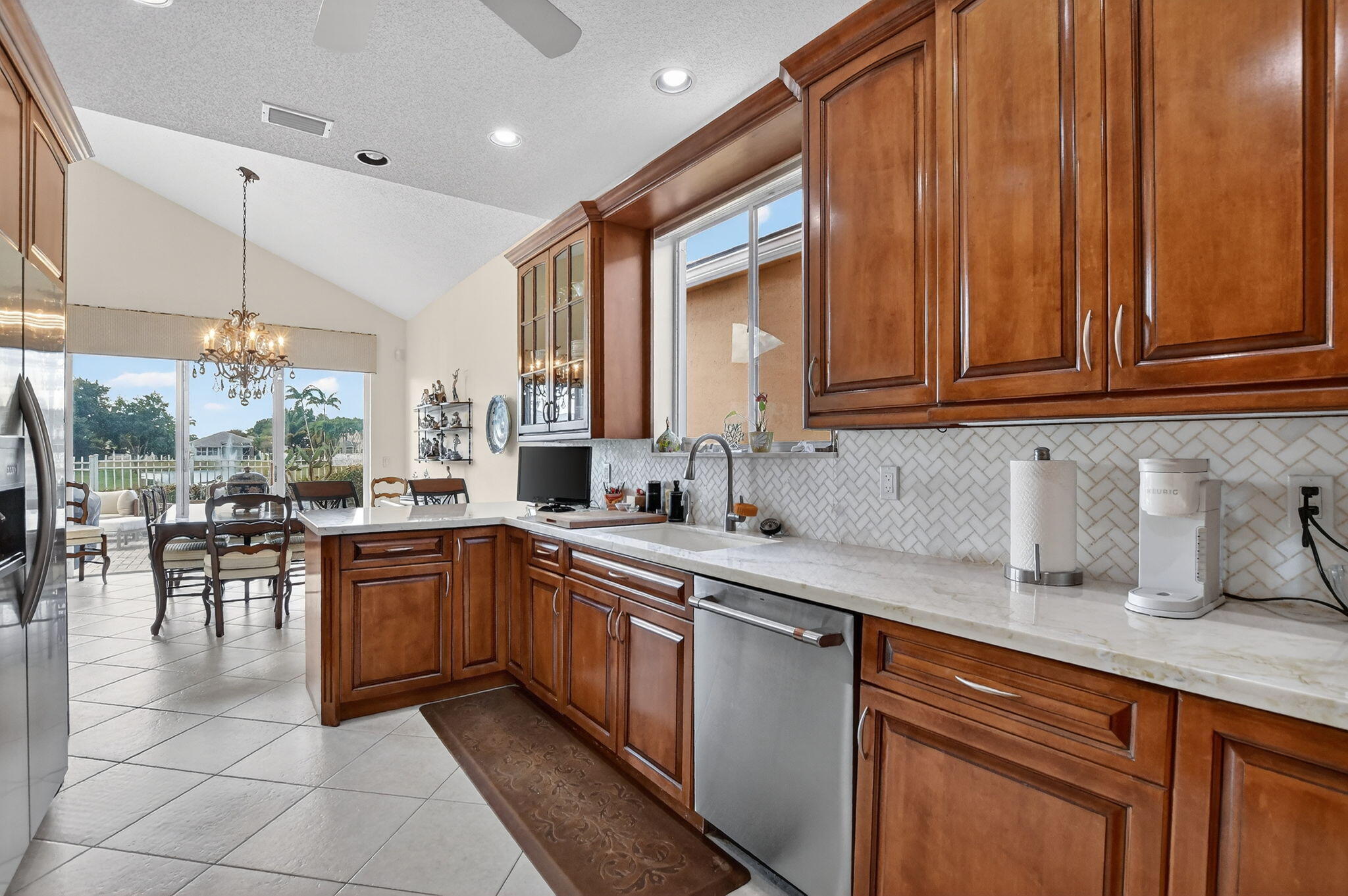 7997 Travelers Tree Drive Boca Raton, FL 33433 - Photo 17 of 54 a kitchen with lots of counter top space and dining table