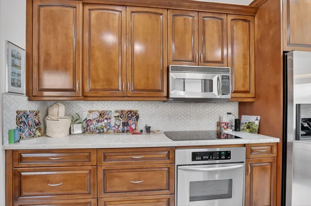 a kitchen with stainless steel appliances granite countertop a refrigerator and cabinets