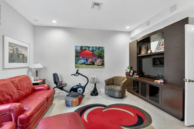 a living room with furniture kitchen view and a flat screen tv