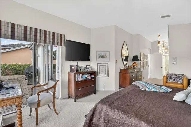 a bedroom with a bed and a flat tv screen on dresser