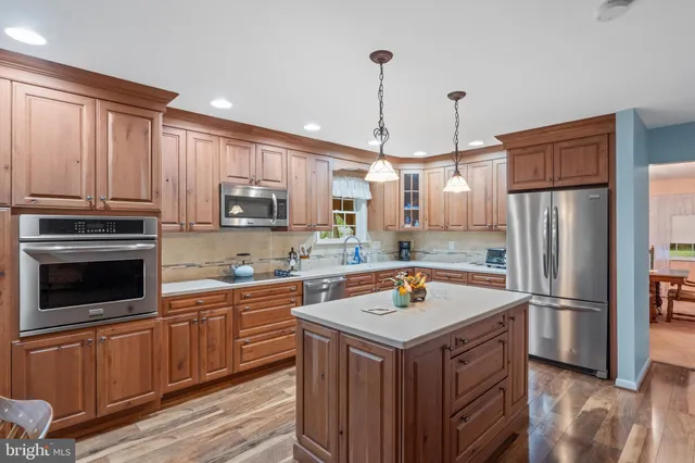 a kitchen with a refrigerator a sink and wooden floor