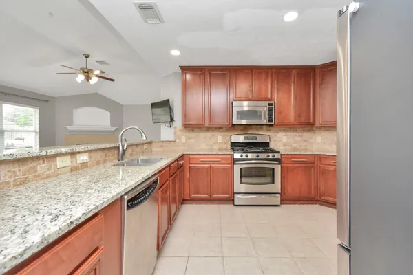 a kitchen with stainless steel appliances granite countertop a stove and a sink