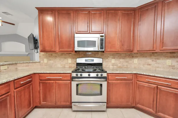 a kitchen with granite countertop wood cabinets and stainless steel appliances