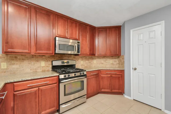 a kitchen with granite countertop wooden cabinets and stainless steel appliances