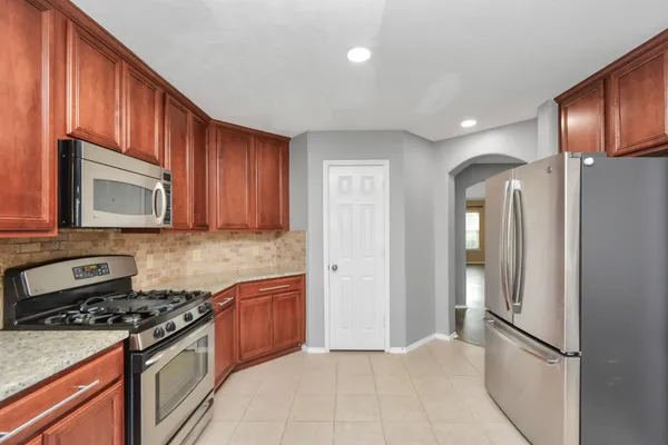 a kitchen with stainless steel appliances granite countertop a refrigerator stove and sink