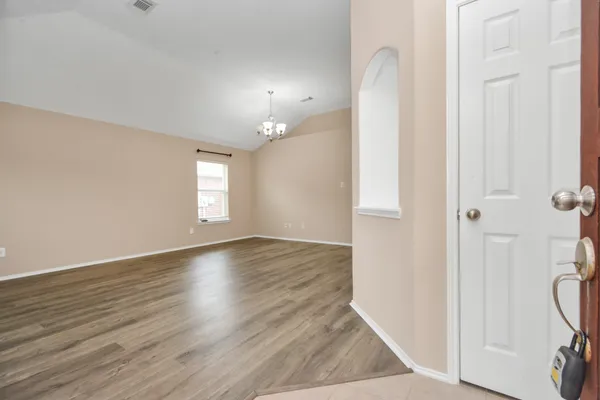 an empty room with wooden floor and a window