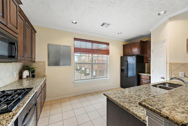 a kitchen with granite countertop a sink stove and refrigerator