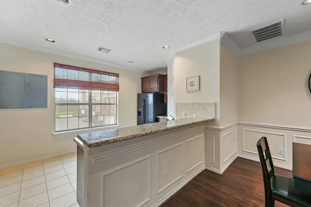 a living room with stainless steel appliances granite countertop a sink and a large window
