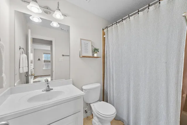 a bathroom with a sink a toilet and a mirror