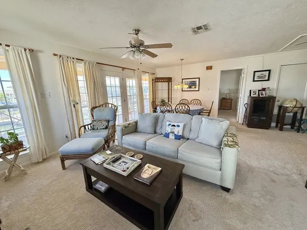 a living room with furniture a ceiling fan and a window